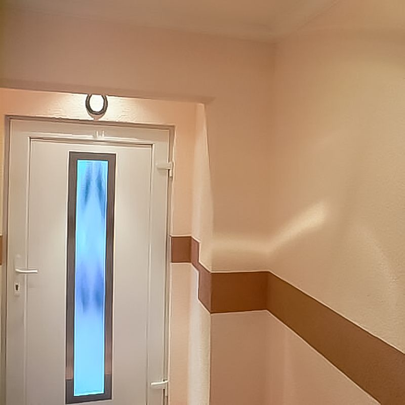 Farbig abgesetzt, führt ein Dekostreifen die Besuchenden ins Haus. Indirekte Beleuchtung sorgt für Gemütlichkeit.