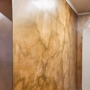 Wandputz goldbraun marmoriert, Lichtreflexe spiegeln sich in der Wand